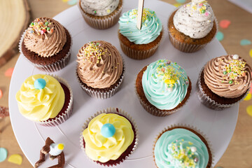 Colorful homemade cupcakes served on a white plate close up still