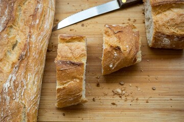 High angle shot of a freshly-baked breast on a wooden cutting board with a knife