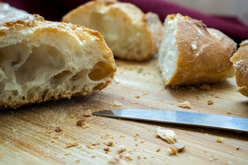 High angle shot of a freshly-baked breast on a wooden cutting board with a knife