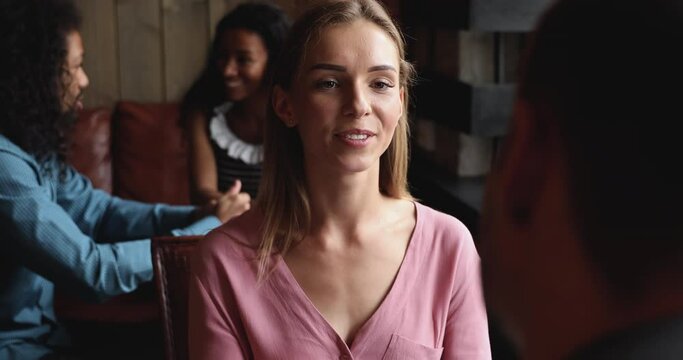 Happy young woman speaking to male friend at meeting or blind date in cafe, smiling girl having conversation with man boyfriend sit at table in public place indoors, friendly communication concept