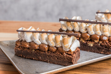 brownie cake with meringue on wooden table