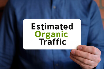 text on a white sign in the hand of a man in a blue shirt