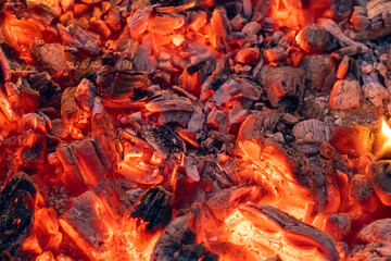 Smoldering charcoal in a bonfire, background texture