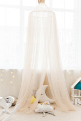 children's room in pastel colors with fabric tent and toys