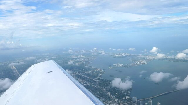 Flying Above Miami, Florida. City View Over Airplane Wing, Passenger POV