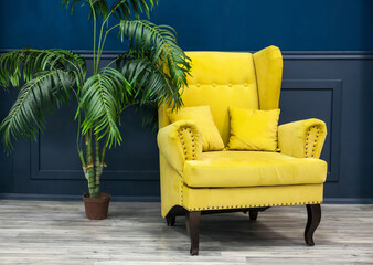 Stylish Yellow chair against a blue wall.