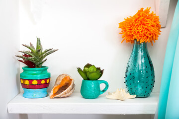 Vintage home decor in Bright colors on white wooden shelf.