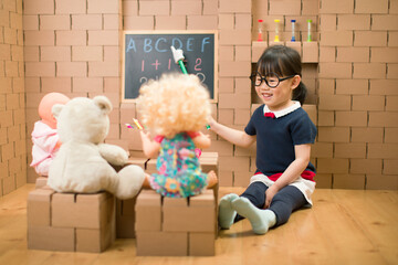 toddler girl pretend play as a teacher at home - obrazy, fototapety, plakaty