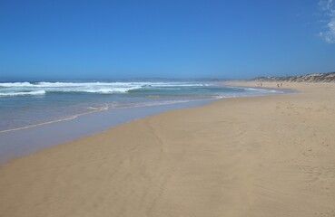 Fototapeta na wymiar Wide sandy beach in Plettenberg Bay, by the Indian Ocean. Garden Route, South Africa, Africa.