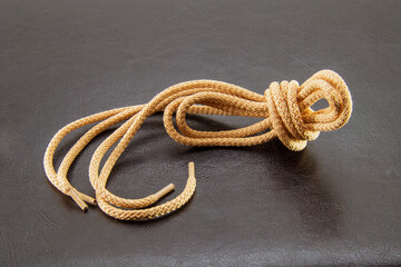 brown laces on a black leather background,shoelaces on a black background,
