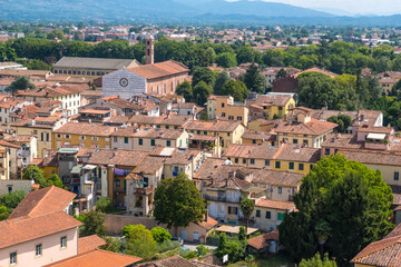 Fototapeta na wymiar Lucca, Italy - August 14, 2019: Panoramic view of Lucca from Guinigi Tower balcony with oak trees, Tuscany, Italy