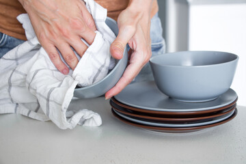 the woman washes the dishes and wipes it
