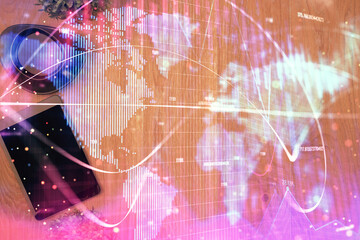 Double exposure of business theme hologram over desktop with phone. Top view. Mobile international trade connection concept.