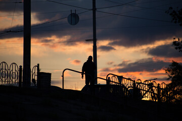 Silhouette of a man on a sunset background in the sity