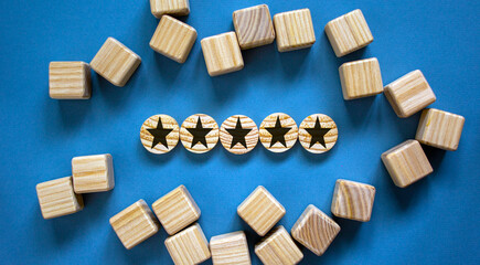 Wood circles with star sign and cubes on paper blue background, copy space. Business concept success process.