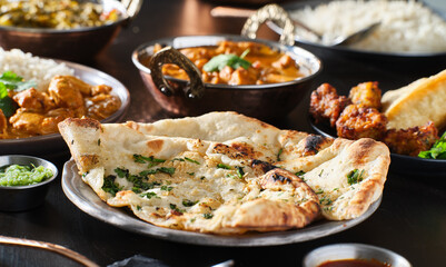 indian naan bread with herbs and garlic seasoning on plate
