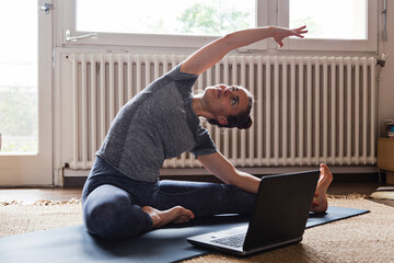 Yoga teacher teaching livestreamed online video class from home