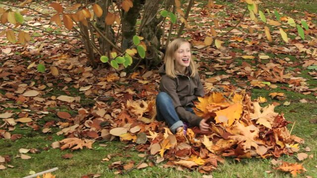 Girl raking fall leaves
