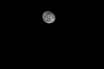 Beautiful almost full moon on black, dark background in the night sky.
