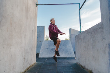 Young sportsman running on the spot outdoor for warming up before parkour training