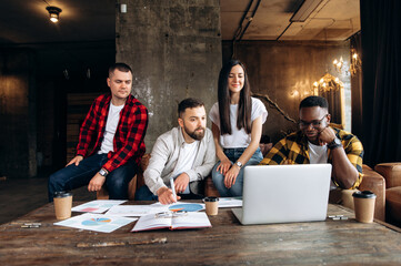 Group portrait of young ambitious startups during working process. A successful business team gathered in its modern office in a friendly atmosphere to develop a new ideas and startups