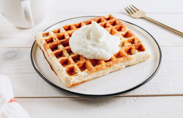 Gluten free Belgian waffles with with rice flour and cup of coffee on white wooden background.