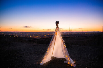 Teepee on top of hill with small chain light