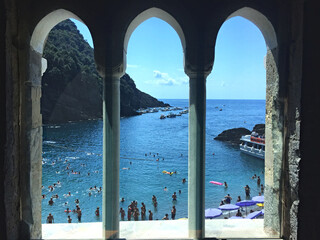 Iconic picturesque view onto the beach and the turquoise Mediterranean sea out of a window of San Fruttuoso abbey