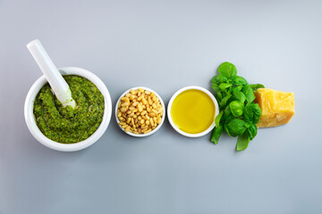 Pesto sauce and ingredients for cooking. Fresh basil, parmesan, nuts and olive oil. Top view.