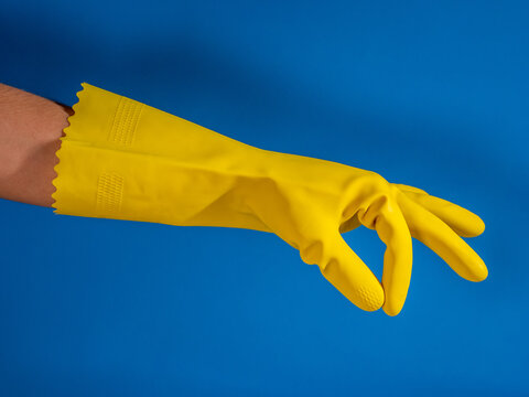girl hands with cleaning gloves making gesture of holding nothing and blue background