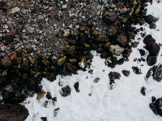 a girl in a dress lies on the rocks by the ocean top view