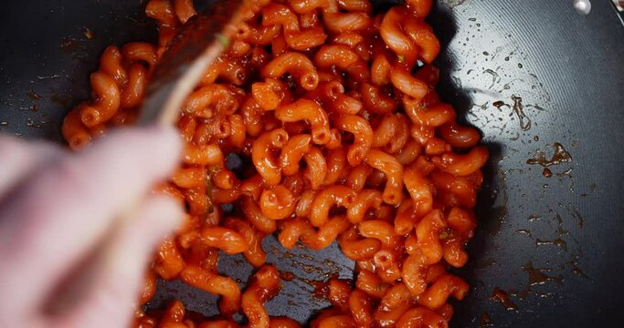 Boiled pasta cavatappi with tomato sauce mix in the pan.