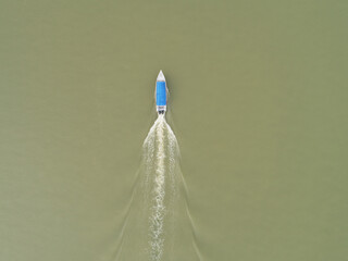 Aerial view of single bot with blue color roof cover cruising at a river