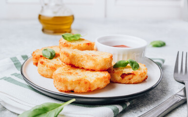 Hash brown or potato pancakes on plate with catsup on light gray background