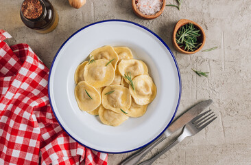 Traditional italian ravioli with rosemary and parmesan served onon an enamel plates. Italian pasta.