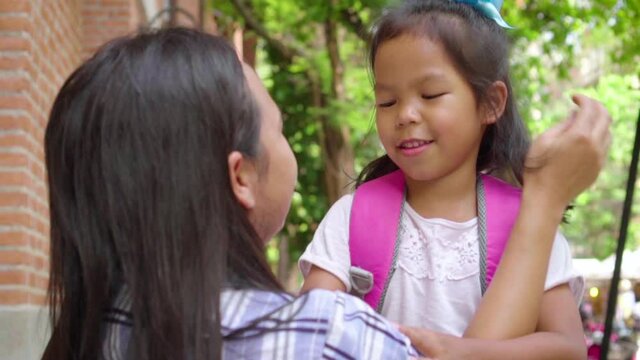 Asian mom caring and talking her daughter before go to school. Back to school concept. Slow motion.