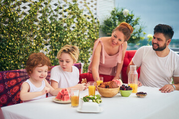 happy family having lunch on rooftop patio at home