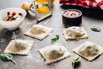 Homemade fresh Italian ravioli pasta with mushrooms on dark background.