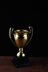 Fototapeta na wymiar Golden trophy against black background