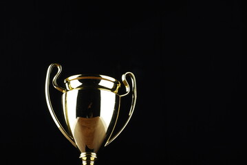 Golden trophy against black background