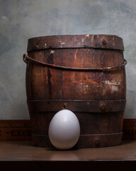 Fototapeta premium egg next to a vintage wooden bucket