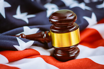 Wooden judge hammer on american flag Justice law
