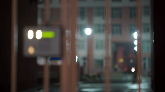 Safety in modern residential building, fenced yard, closed gate with electronic lock and intercom at night.