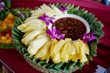 Sliced green mango with shrimp paste on banana leave tray
