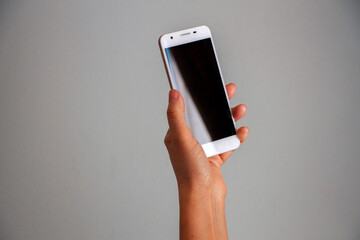Fototapeta na wymiar Mano de mujer sosteniendo un teléfono celular en su mano