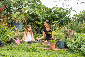 Mother and daughter exercise yoga outdoors