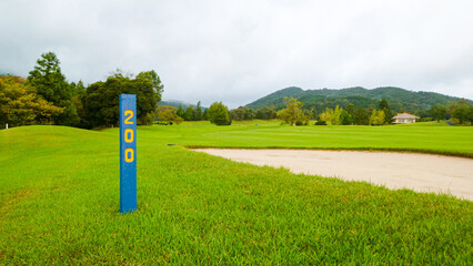 ヤード杭が立っているゴルフ場の景色