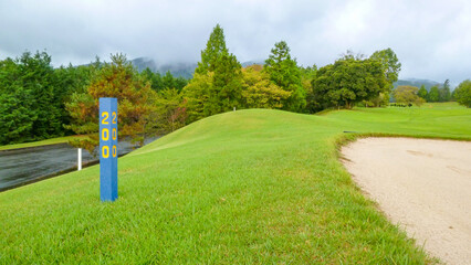 ヤード杭が立っているゴルフ場の景色