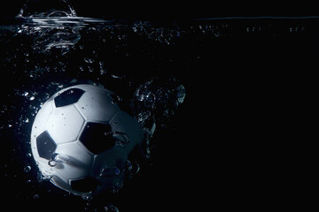 Naklejka premium Soccer ball splashing into water