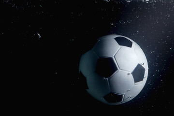Fototapeta premium Soccer ball splashing into water